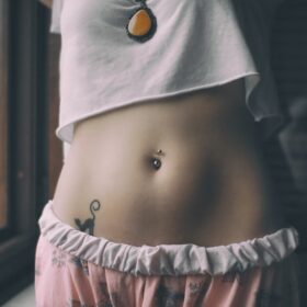 woman in white crop shirt with tattoo on her belly